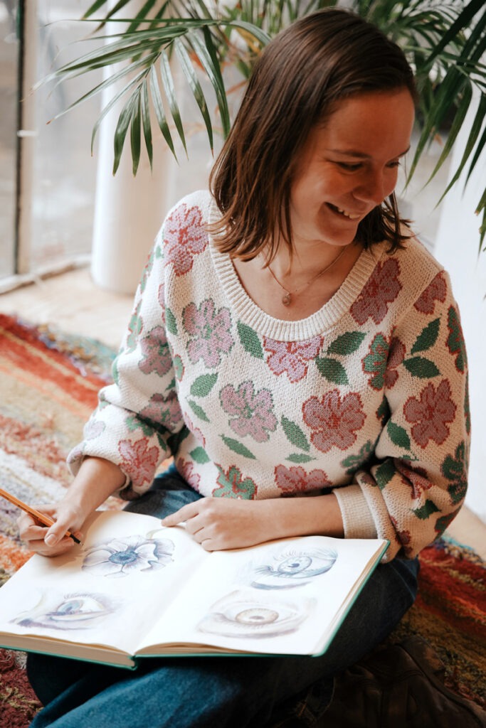 photo de Sophie Bortier, graphiste et illustratrice freelance, en train de dessiner dans son carnet